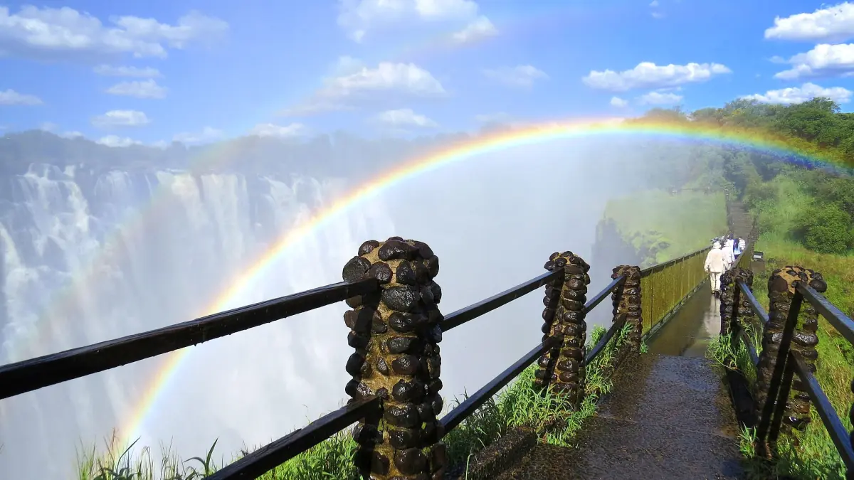 A rainbow over Victoria Falls from a viewpoint path